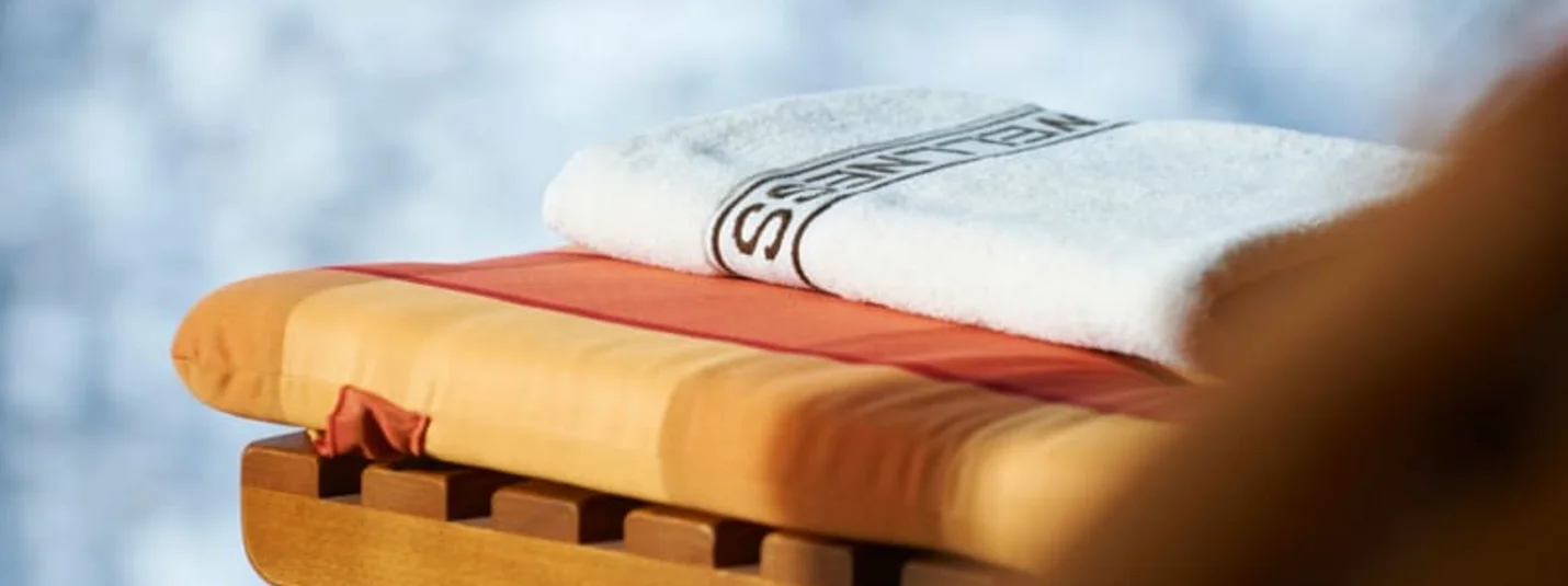 Premium 10 Tage Handdoek op houten stoel met kussen en wazige achtergrond