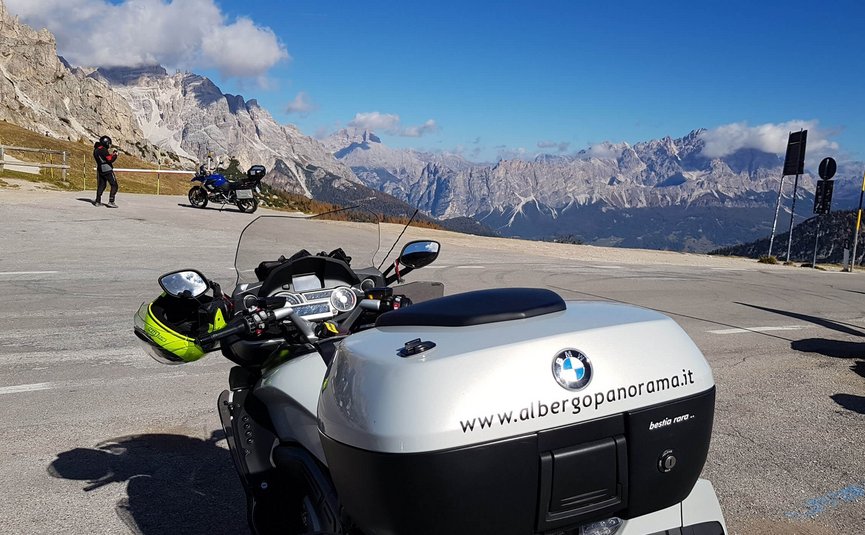 Albergo Panorama *** © Daniele Rodorigo Motorrad mit Helm auf Bergstraße vor Panorama der Dolomiten