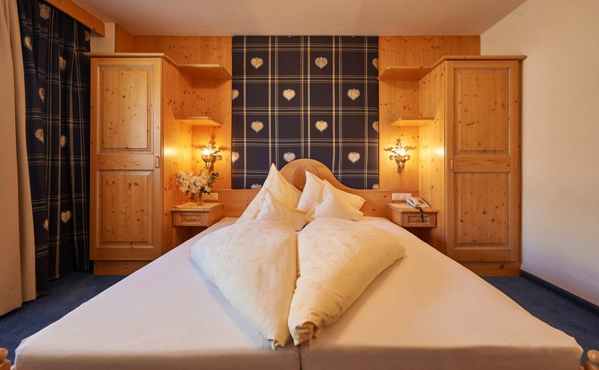 Gemütliches Schlafzimmer mit Holzschränken und herzförmiger Bettdecke