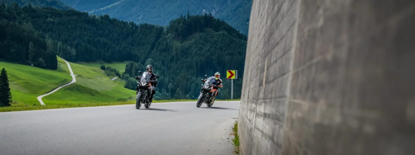 6 Tage Motorradfahren im Zillertal Zwei Motorradfahrer auf kurviger Bergstraße mit bewaldeten Bergen im Hintergrund