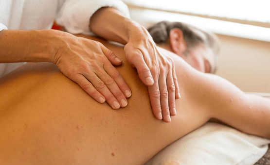 Person erhält Rückenmassage auf Liege