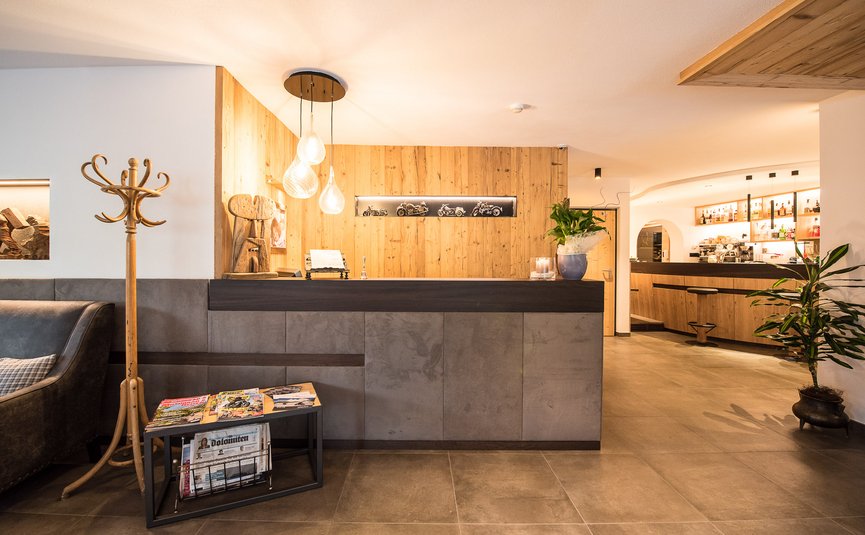 Hotel Florian ***S © Arik Oberrauch Moderne Hotelrezeption mit Holzverkleidung und gemütlicher Beleuchtung