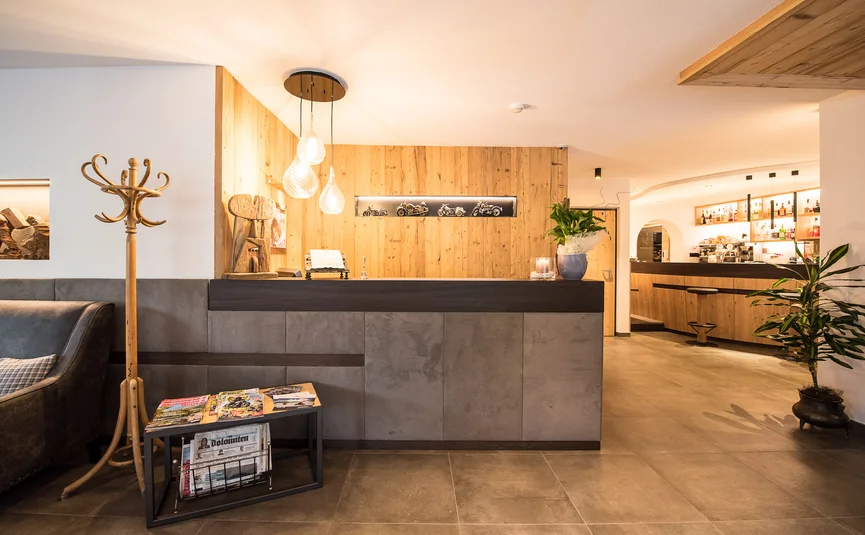 Modern hotel reception area with wood paneling and warm lighting