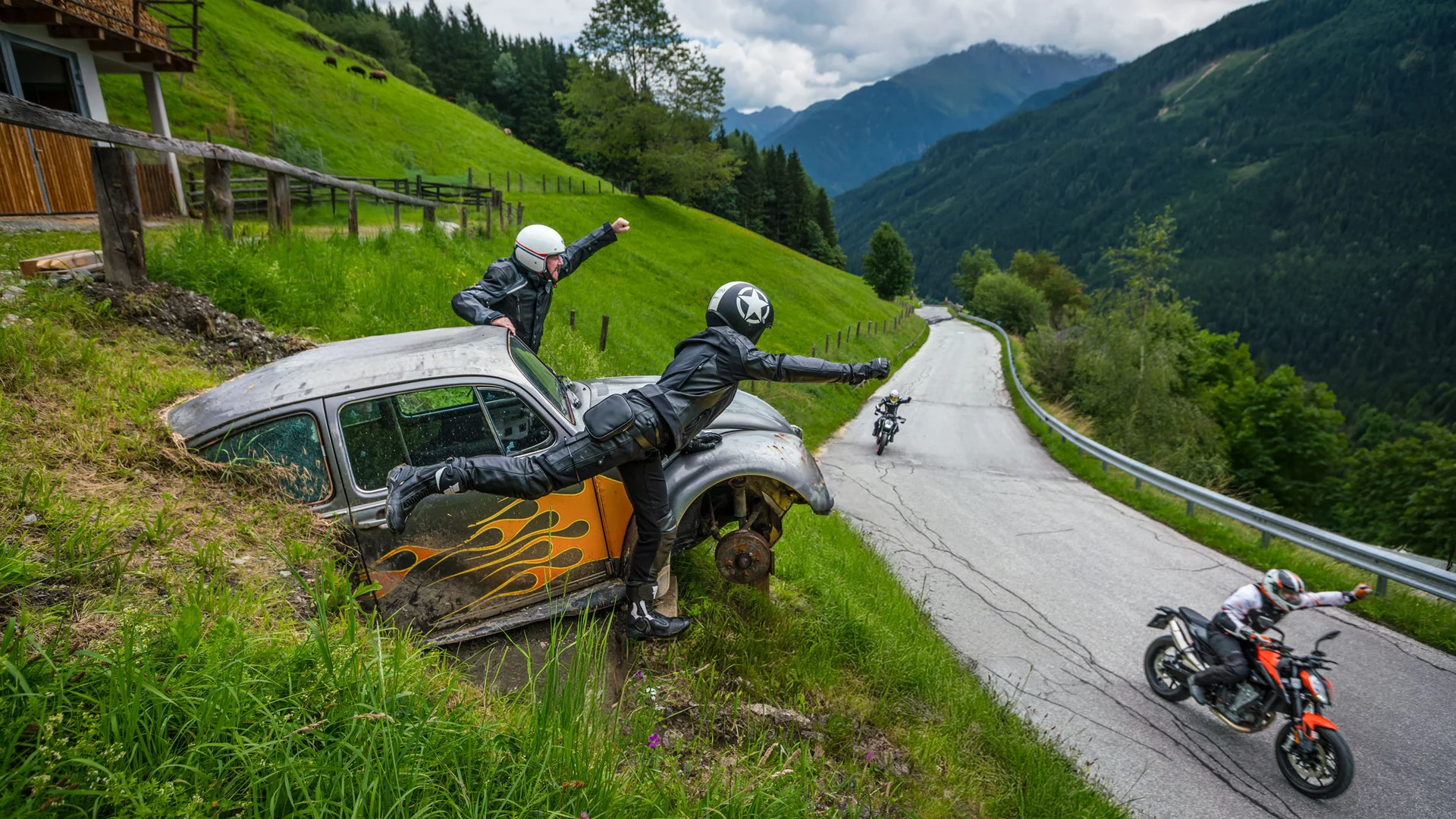 Motorcyclists waving from an old car by the roadside in the mountains