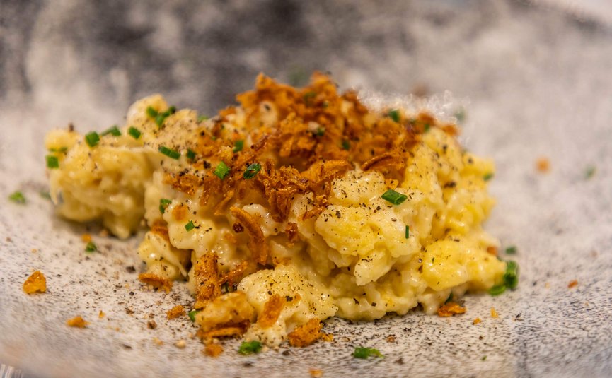 Kaas spaetzle met gebakken uitjes en bieslook op een bord