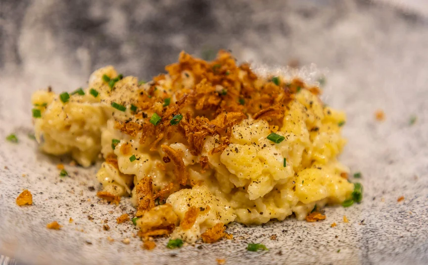 Käse-Spätzle mit Röstzwiebeln und Schnittlauch auf einem Teller
