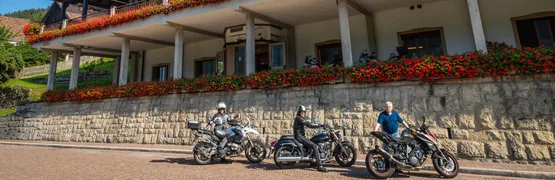 Bellavista hotel with three motorcycles and riders parked outside on a sunny day