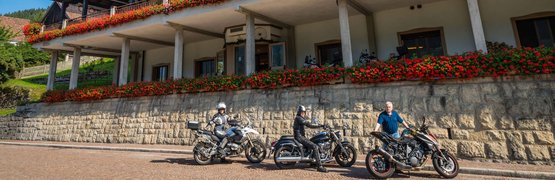 Hotel Bellavista mit drei Motorrädern und Fahrern davor bei sonnigem Wetter