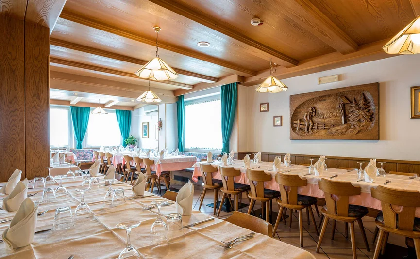 Gezellige restaurantinterieur met gedekte tafels en houten plafond