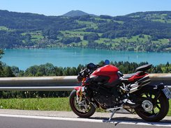 Attersee – Salzkammergut © Armin Hoyer Rotes Motorrad auf Bergstraße mit See und Hügeln im Hintergrund