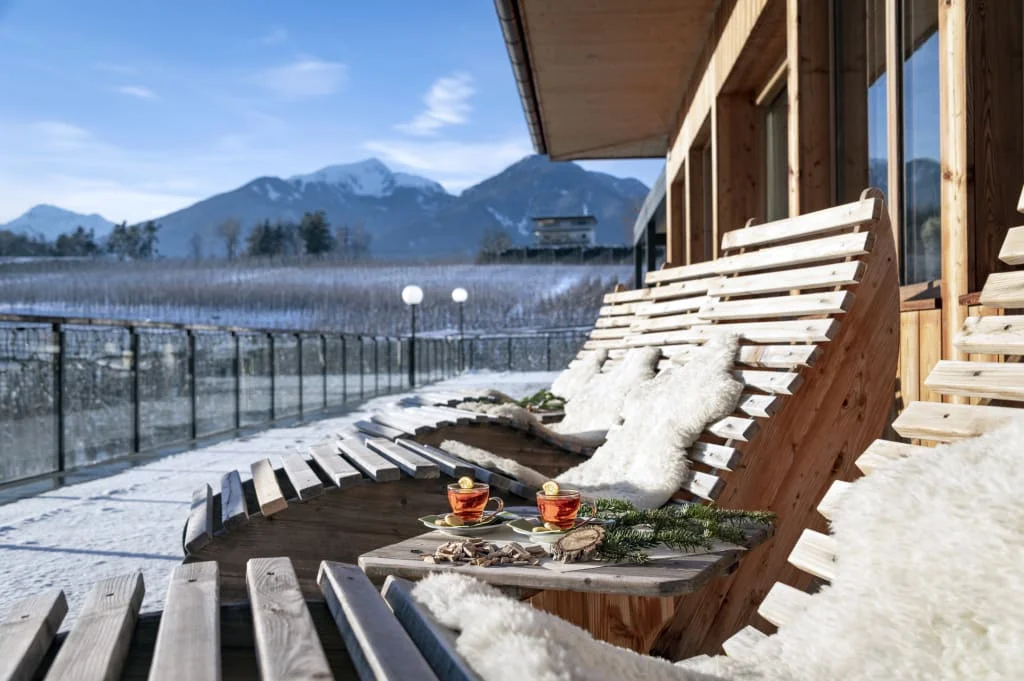 5=4 Wellness Power Package Holzliegen mit Fellen auf Terrasse mit Bergblick und zwei Teetassen