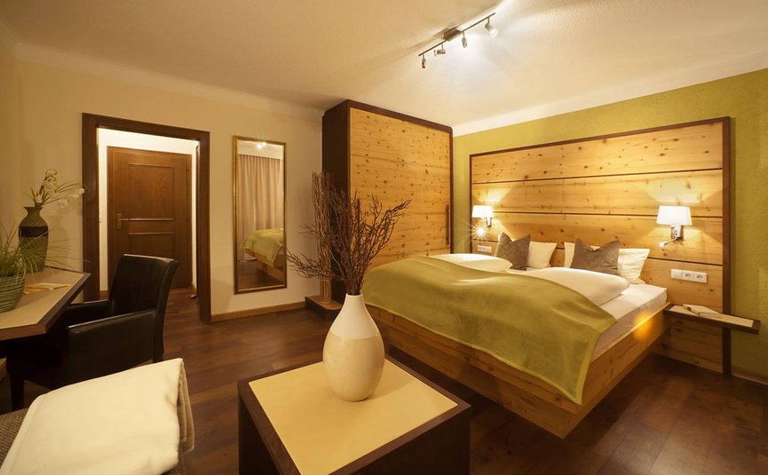 Gemütliches Hotelzimmer mit Doppelbett und Holzverkleidung