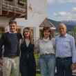 Familienfoto vor einem Haus mit Bergen im Hintergrund