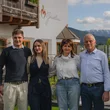 Family photo in front of a house with mountains in the background