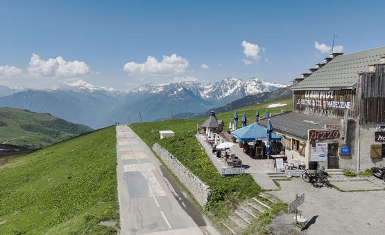 Motorvakantie in de Maurienne Bergrestaurant met terras en uitzicht op besneeuwde bergen bij heldere lucht