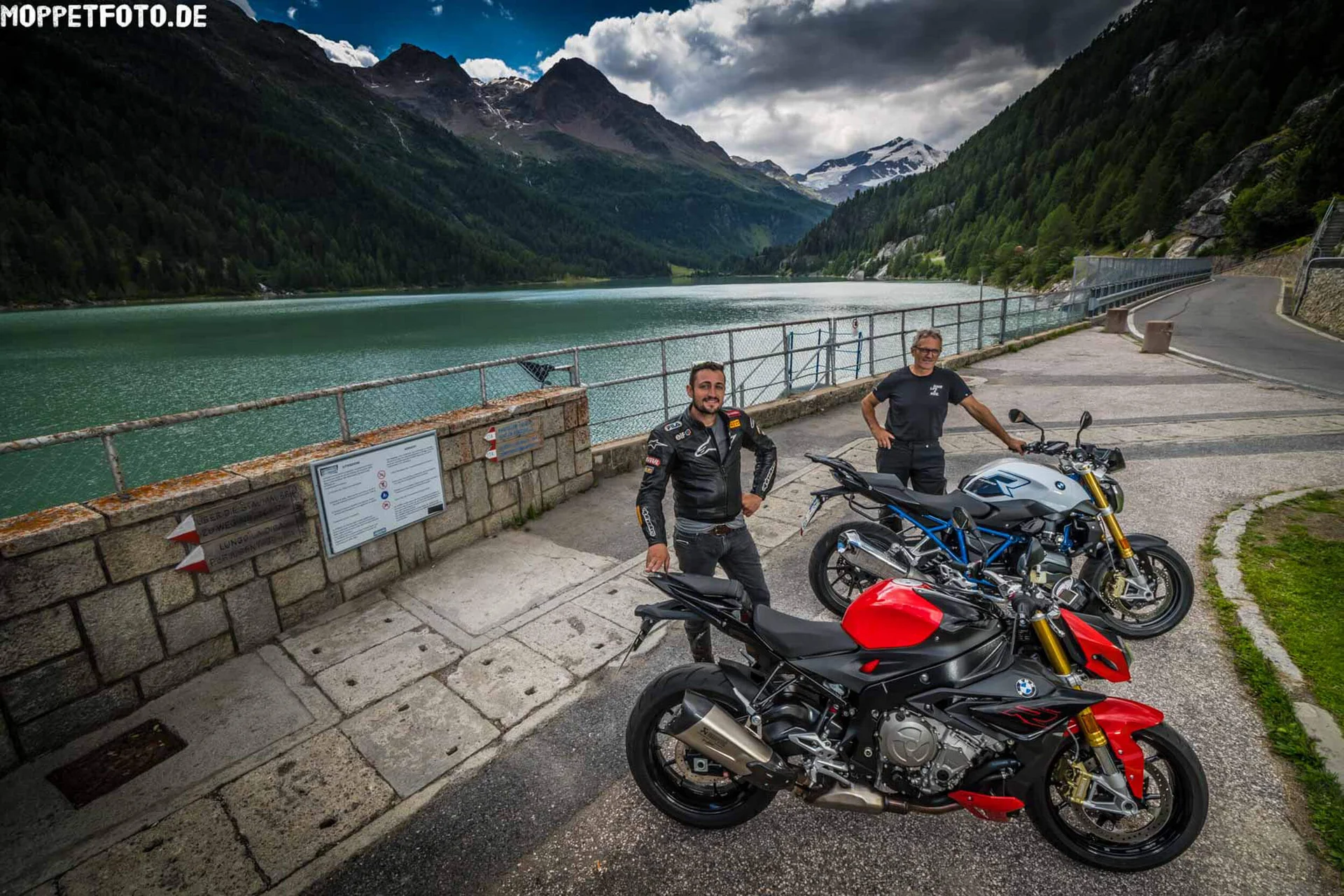 Motorbike holiday © Moppetfoto.de Two men with motorcycles by a lake surrounded by mountains
