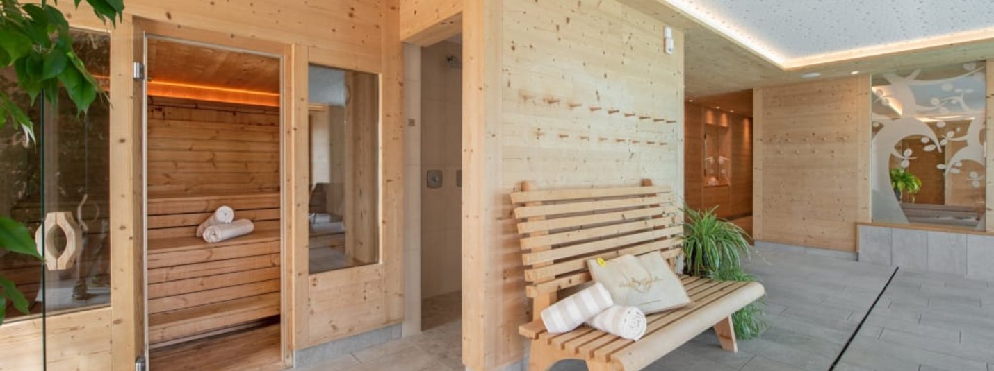 Winter Wellness Weekend 3 Nächte Hell beleuchteter Saunabereich mit Holzbänken und Handtüchern