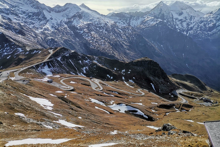 Serpentinenstraße in schneebedeckten Alpen mit Bergen im Hintergrund