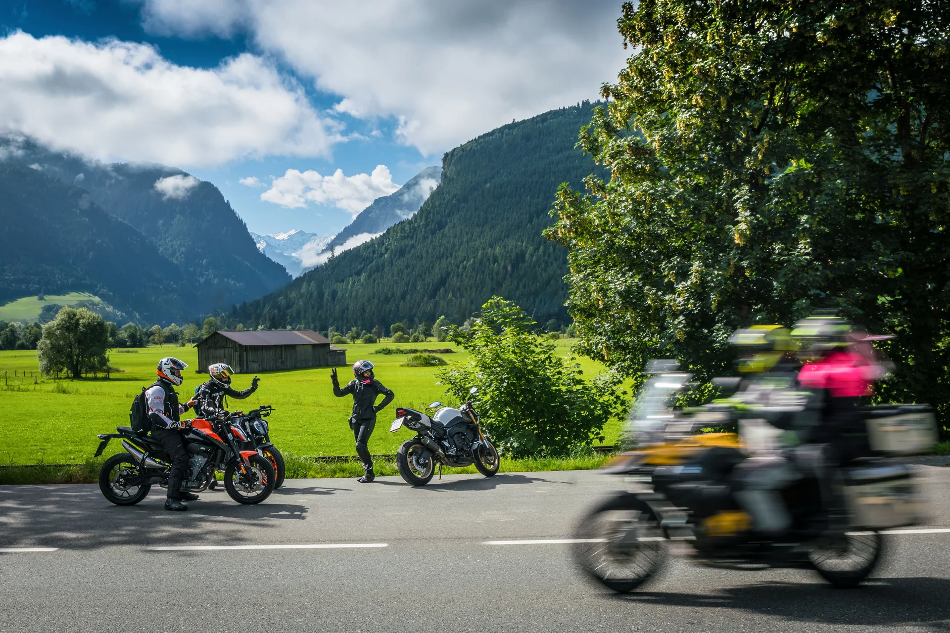 Motorradurlaub © Moppetfoto.de Motorradfahrer vor Berglandschaft mit grünen Wiesen und blauem Himmel