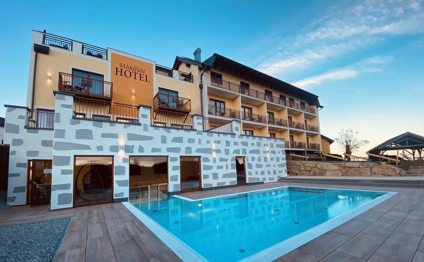 Hotelgebäude mit Außenpool bei klarem Himmel