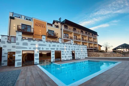 Hotelgebäude mit Außenpool bei klarem Himmel