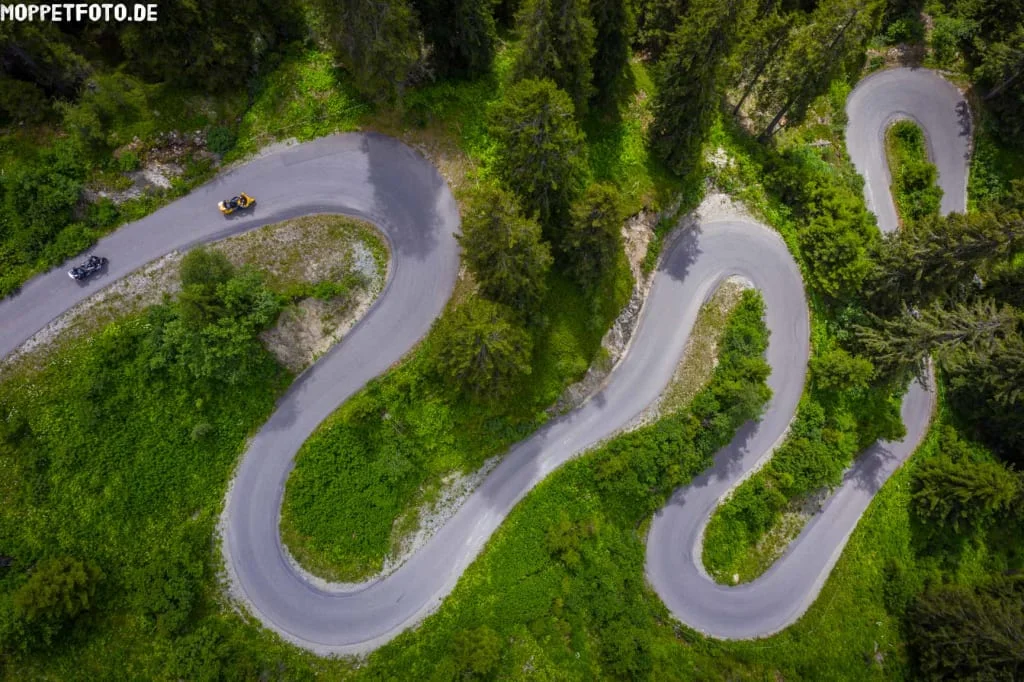 Serpentinenstraße im Wald mit zwei Motorrädern von oben