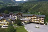 Sammelanfragen © Erlebnishotel Kärnten Mölltal Gelbes Hotelgebäude in grüner Berglandschaft mit Autobahnbrücke im Hintergrund