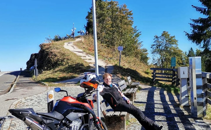 Panoramatour door Rossfeld Motor en persoon op bank bij Roßfeldstraße op 1560 meter hoogte