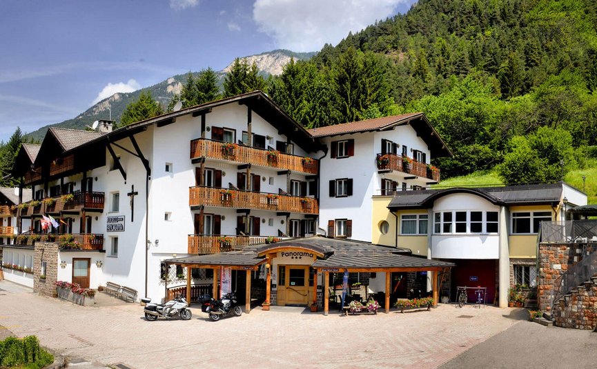 Albergo Panorama *** © Albergo Panorama Hotelgebäude mit Balkonen und Motorrädern vor Bergwald im Hintergrund