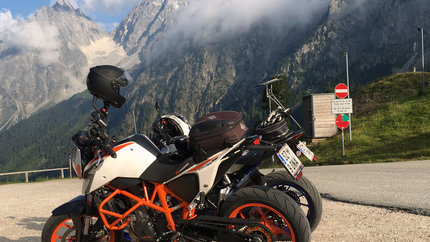 Motorräder geparkt mit Bergblick und bewölktem Himmel