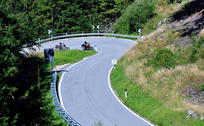 Motorradfahrer auf einer engen Bergstraße mit Haarnadelkurve