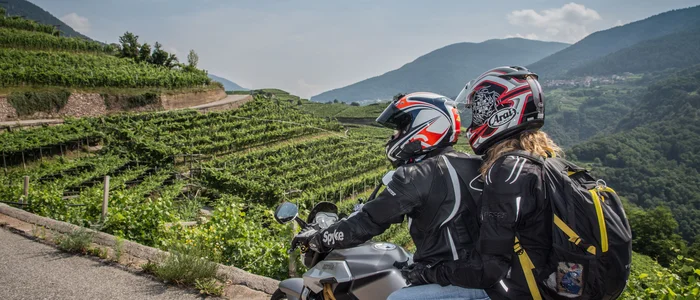 Hotel La Stüa **** © A. Monticelli Zwei Motorradfahrer mit Helmen auf Straßenkurve mit grünen Hügeln