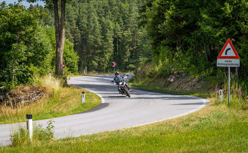 Wohlfühlhotel Rockenschaub **** © Moppetfoto.de Motorradfahrer fährt durch eine scharfe Kurve auf einer Straße im Wald