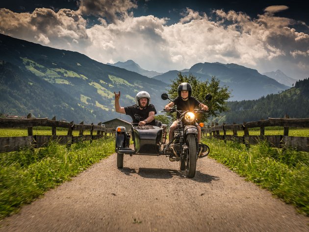 Qualitätsversprechen © Moppetfoto.de Zwei Personen auf Motorrad mit Beiwagen auf Landstraße in Berglandschaft