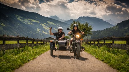 Qualitätsversprechen © Moppetfoto.de Zwei Personen auf Motorrad mit Beiwagen auf Landstraße in Berglandschaft