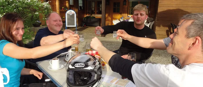 Group of five people toasting with shot glasses during outdoor break