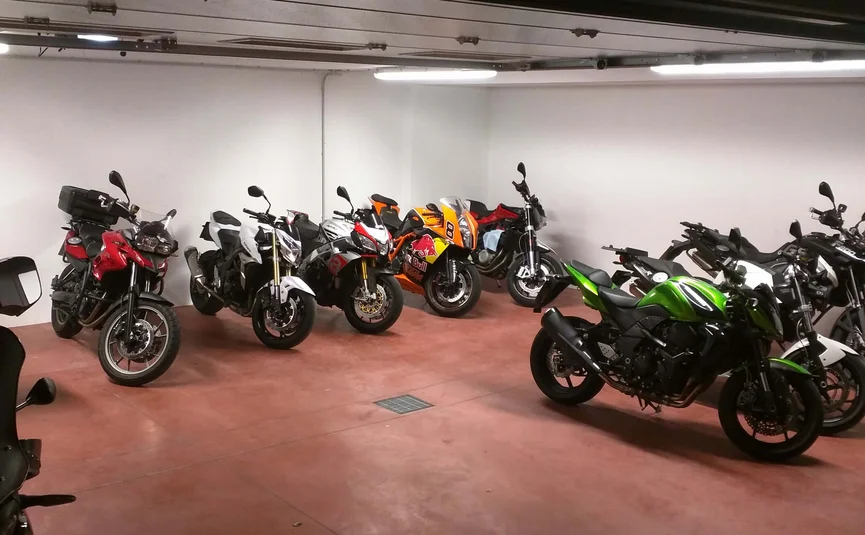 Motorfietsen geparkeerd in een garage met rode vloer en witte muren