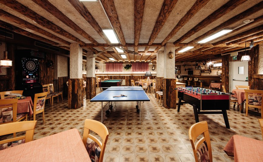 Spielzimmer mit Tischtennis, Kicker, Billard und Darts in rustikalem Raum