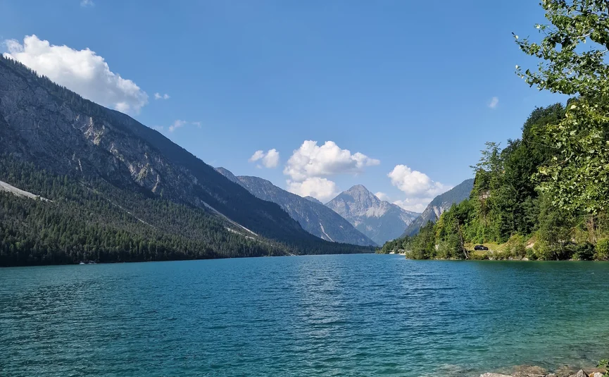 Clear mountain lake with mountains and blue sky in the background