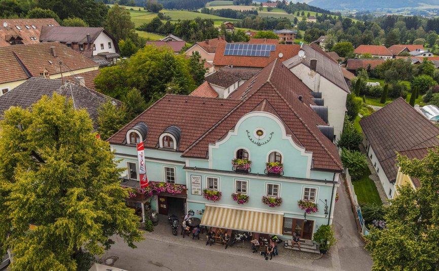 Gasthof Pension Drei Hacken *** © Alexander Seger Altes Gasthaus mit blauen Fassade und Blumen in einem Dorf mit Bergen im Hintergrund