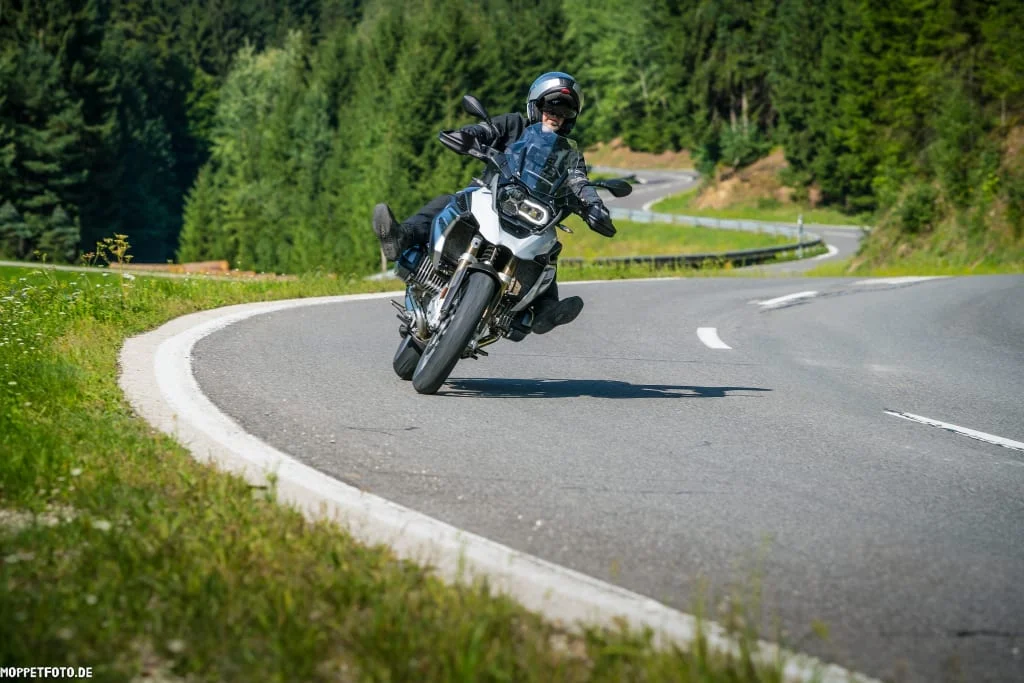 KURVENQUICKY 2026/27 Motorrijder rijdt een bocht op een bergweg