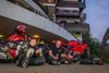 Sammelanfragen © Moppetfoto.de Drei Motorradfahrer sitzen lachend vor roten Motorrädern mit Getränken