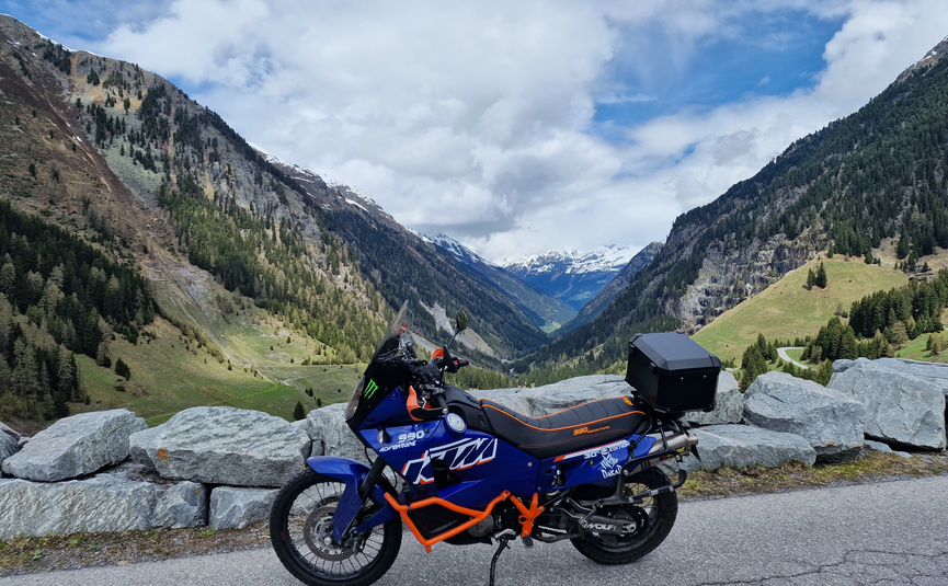 MoHo Schönauer Hof Tour 5 Kaunertal Glacier Variant 2 Motorcycle parked with mountain valley and cloudy sky background