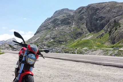 Kleine Hausrunde - Moar's Hotel Rotes Motorrad auf Bergstraße mit Felsen und grünen Hängen im Hintergrund