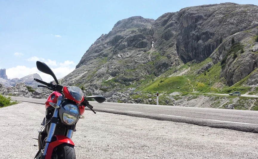 Kleine Hausrunde - Moar's Hotel Rotes Motorrad auf Bergstraße mit Felsen und grünen Hängen im Hintergrund
