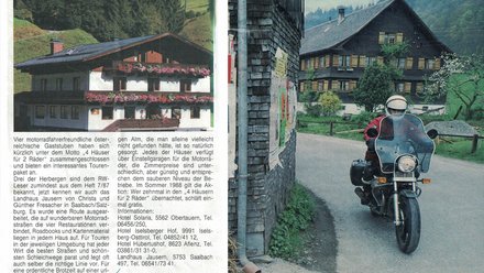 Motorradfahrer auf Landstraße mit traditionellen österreichischen Häusern