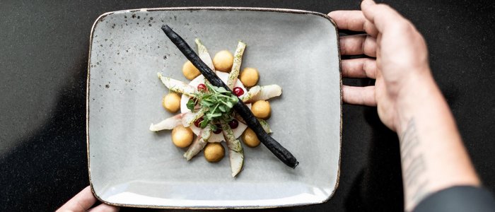 Motorrad- & Spa Hotel Traube Post am Reschensee **** © Theiner Karl-Heinz & Co KG Hände halten einen Teller mit künstlerisch angerichtetem Gourmetgericht