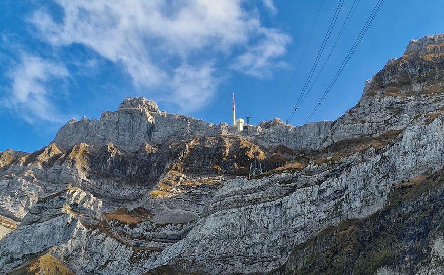 MoHo Schönauer Hof tour 11 Schwägalp Mountain with rocky cliffs, green tree, cable car lines under blue sky