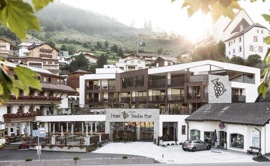 Motorrad- & Spa Hotel Traube Post am Reschensee **** © Theiner Karl-Heinz & Co KG Hotel Traube Post in einem Bergdorf bei Sonnenuntergang