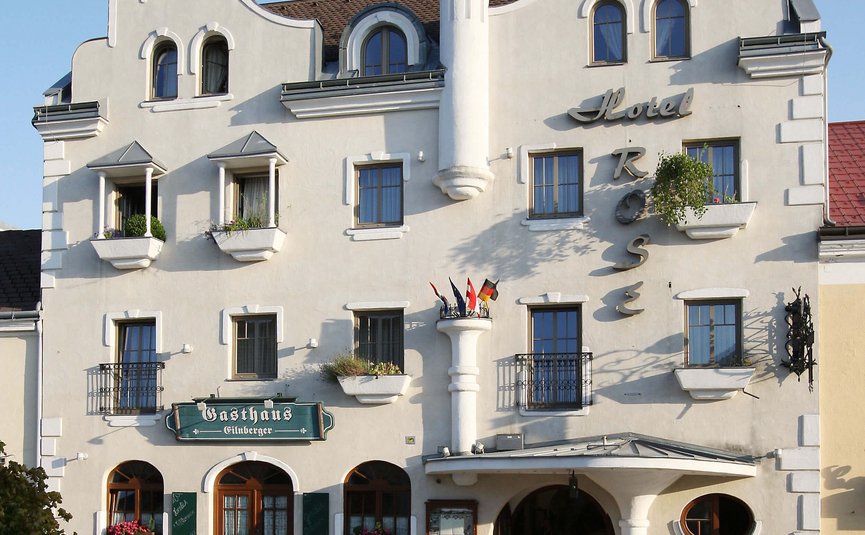 Historisches weißes Hotelgebäude mit Turm und Gasthaus im Erdgeschoss